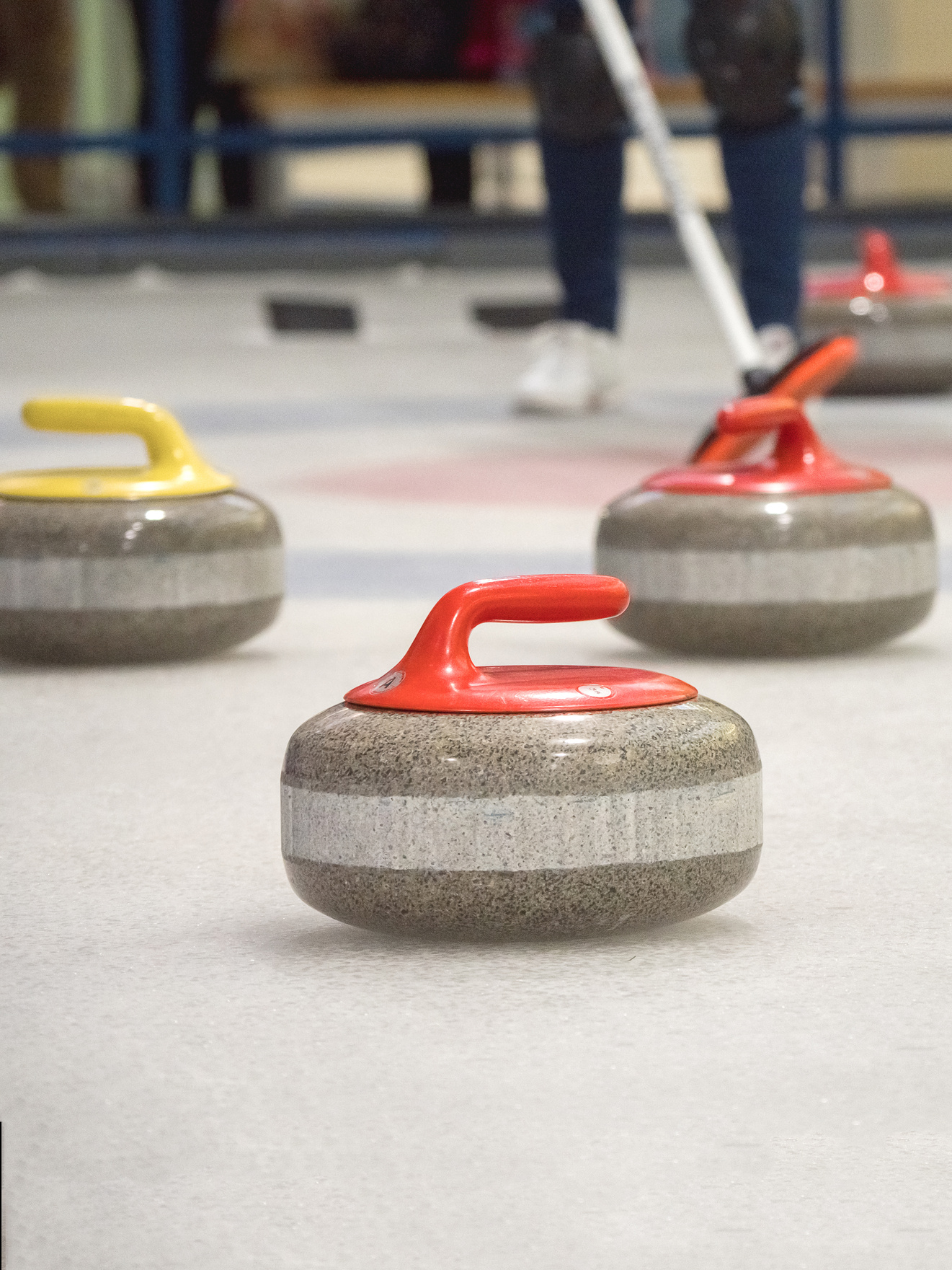 Curling stone on ice of a indoors rink.
